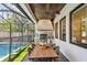 A fully equipped outdoor kitchen features a grill, dining area, and a view of the refreshing pool at 2402 W Parkland Blvd, Tampa, FL 33609