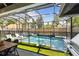 Outdoor pool area with fountains, a hot tub, and a partially screened-in patio and outdoor kitchen at 2402 W Parkland Blvd, Tampa, FL 33609