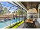 Screened-in outdoor area features a sparkling pool, outdoor kitchen, and dining space at 2402 W Parkland Blvd, Tampa, FL 33609