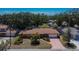 An aerial view of a single-story home showing the driveway, mature trees, landscaping and surrounding neighborhood at 2505 E 19Th Ave, Tampa, FL 33605