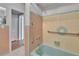 Bathroom showcasing a pastel bathtub with updated shower head, grab bar, and pink and yellow tiled walls at 2505 E 19Th Ave, Tampa, FL 33605