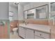 Bathroom featuring a large mirror, white sink and cabinets, toilet, and light pink tile with teal trim at 2505 E 19Th Ave, Tampa, FL 33605