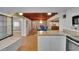 Open-concept kitchen flows into a dining area, featuring white cabinets, granite counters, and wood-look flooring at 2505 E 19Th Ave, Tampa, FL 33605