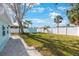 Lush backyard featuring mature palm trees and a pristine white privacy fence, perfect for outdoor living at 280 41St Ave, St Pete Beach, FL 33706