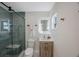 Modern bathroom with a glass shower, wooden vanity, and illuminated mirror at 280 41St Ave, St Pete Beach, FL 33706