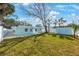 Landscaped front yard with large tree, blue exterior, white privacy fence, and shed at 280 41St Ave, St Pete Beach, FL 33706