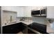 Modern kitchen featuring a gold faucet, black and white cabinets, and stainless steel appliances at 280 41St Ave, St Pete Beach, FL 33706