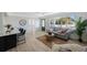 Bright living room featuring a sofa, round wooden table and access to the kitchen and front door at 280 41St Ave, St Pete Beach, FL 33706