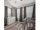 Well-lit Bedroom with white dresser, grey curtains, and hardwood floors at 3056 Pointeview Dr, Tampa, FL 33611
