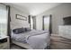 This main bedroom includes a king-size bed, dual windows, a dresser, and wood-look flooring for a comfortable space at 3056 Pointeview Dr, Tampa, FL 33611