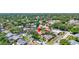 Aerial view of a home in a leafy neighborhood with a pool and colorful exterior at 3122 Lake Valencia E Ln, Palm Harbor, FL 34684