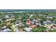 Aerial view of neighborhood showcasing lush greenery, nearby lake, and a home with a sparkling pool at 3122 Lake Valencia E Ln, Palm Harbor, FL 34684