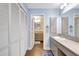 Bright bathroom with double vanity, wood floors, and an open doorway to an adjacent bathroom at 3122 Lake Valencia E Ln, Palm Harbor, FL 34684