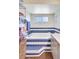 Bathroom featuring a soaking tub with blue and white tile surround and a shelving unit for towels at 3122 Lake Valencia E Ln, Palm Harbor, FL 34684