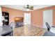 Bedroom featuring wood flooring, a ceiling fan and light peach colored walls at 3122 Lake Valencia E Ln, Palm Harbor, FL 34684