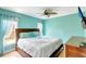 Bedroom with a bed, fan, light blue walls and curtains, and two windows to let the sun in at 3122 Lake Valencia E Ln, Palm Harbor, FL 34684