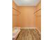 Walk in closet featuring wood flooring, light peach colored walls, and two wooden bars at 3122 Lake Valencia E Ln, Palm Harbor, FL 34684