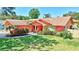 Charming single-story home with a well-manicured lawn and a colorful exterior at 3122 Lake Valencia E Ln, Palm Harbor, FL 34684