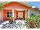 Inviting front entrance with colorful walls, plants, chairs and double doors leading to the main entrance at 3122 Lake Valencia E Ln, Palm Harbor, FL 34684