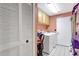 Laundry room featuring laundry machines, light orange walls, and built-in cabinets at 3122 Lake Valencia E Ln, Palm Harbor, FL 34684