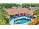 A view of a pool and patio from an upper angle with an open porch nearby at 3122 Lake Valencia E Ln, Palm Harbor, FL 34684