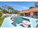 Backyard pool with blue brick and fun inflatables surrounded by a lush tropical landscape at 3122 Lake Valencia E Ln, Palm Harbor, FL 34684
