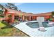 Backyard pool featuring an orange house, an orange umbrella, and a basketball hoop at 3122 Lake Valencia E Ln, Palm Harbor, FL 34684