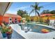 Inviting backyard pool area with palm trees, patio seating, and a vibrant, well-maintained pool at 3122 Lake Valencia E Ln, Palm Harbor, FL 34684