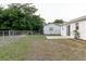 Backyard showing a chainlink fence, a concrete patio, green grass, and a storage shed at 3139 Corona Dr, Holiday, FL 34690