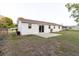 Exterior view of the home's backyard with a concrete patio and low-maintenance lawn at 3139 Corona Dr, Holiday, FL 34690