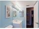 Bright bathroom showcasing a modern vanity, illuminated mirror, and blue accent wall at 3139 Corona Dr, Holiday, FL 34690