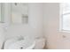All-white bathroom featuring a pedestal sink, toilet, and large mirror at 3139 Corona Dr, Holiday, FL 34690