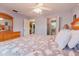 Bright bedroom features a floral comforter, ceiling fan, and ensuite bathroom access at 3139 Corona Dr, Holiday, FL 34690