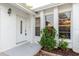 Close-up of a front door with textured white walls and a green shrub at 3139 Corona Dr, Holiday, FL 34690