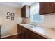 View of kitchen countertop and cabinets with a wine rack near the window with blinds at 3139 Corona Dr, Holiday, FL 34690