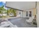 Covered patio area with white chairs and access to the backyard and interior at 3300 Jackson N St, St Petersburg, FL 33704