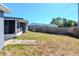 View of backyard featuring a wood fence, grass and exterior of house at 3445 Briar Cliff Dr, Holiday, FL 34691