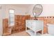 Bathroom features a white vanity, round mirror, and tiled shower with seat at 3445 Briar Cliff Dr, Holiday, FL 34691