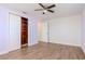 Bedroom includes ceiling fan, wood laminate flooring, closet and view to the hall at 3445 Briar Cliff Dr, Holiday, FL 34691