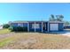 Charming single-story home with blue siding, front porch, and an attached one car garage at 3445 Briar Cliff Dr, Holiday, FL 34691