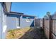 Side yard with the exterior of the house and a view of a wooden fence at 3445 Briar Cliff Dr, Holiday, FL 34691