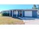 Charming single-story home with blue siding, front porch, and an attached one car garage at 3445 Briar Cliff Dr, Holiday, FL 34691