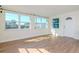 Bright living room with modern wood flooring and large windows filling the space with sunlight at 3445 Briar Cliff Dr, Holiday, FL 34691