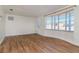 Inviting living room with wood-look floors, large window, and a view of the front yard at 3445 Briar Cliff Dr, Holiday, FL 34691