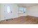 Bright living room showcasing wood-look flooring, a white door, and a bay window at 3445 Briar Cliff Dr, Holiday, FL 34691