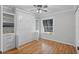 Cozy bedroom with hardwood floors, Murphy bed, built-in shelves, and natural light at 3497 Coquina Key Se Dr, St Petersburg, FL 33705