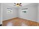 Bright bedroom with hardwood floors, a ceiling fan, and natural light from two windows at 3497 Coquina Key Se Dr, St Petersburg, FL 33705