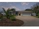 Charming single-story home featuring a brick driveway, lush landscaping, and an attached two-car garage at 3497 Coquina Key Se Dr, St Petersburg, FL 33705