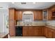 Kitchen with wooden cabinetry, granite countertops and stainless steel dishwasher at 3497 Coquina Key Se Dr, St Petersburg, FL 33705