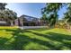 Spacious backyard with lush green grass and mature trees offers a serene outdoor experience at 3629 Lake Breeze Dr, Land O Lakes, FL 34639